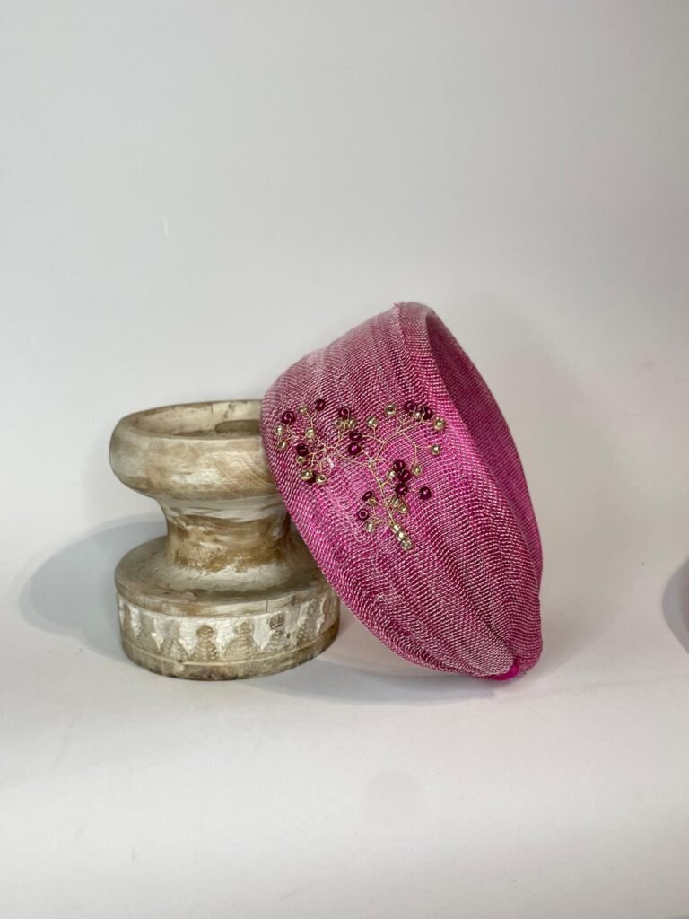 Diadema de sinamay seda frambuesa con detalles granates y oro viejo para invitada.