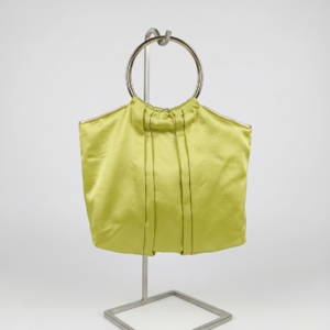 Bolso de satén verde lima artesanal con asa circular plateada en estudio.